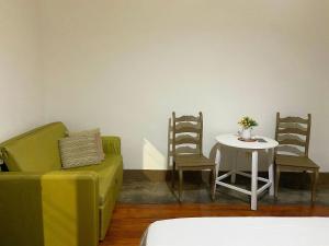 a living room with a couch and a table and chairs at kitnet no centro histórico in São João del Rei