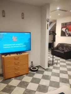 a living room with a flat screen tv on a dresser at Apartament Pod Bukami in Łaziska Górne
