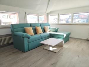 a living room with a blue couch and a table at Sweet Home Longarone in Longarone