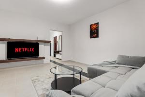 een woonkamer met een bank en een tv bij Modern 1BR Retreat Coffee & Peace in Boekarest