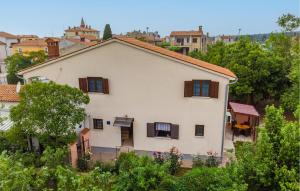 une maison blanche avec des fenêtres et des arbres à volets marron dans l'établissement 1 Bedroom Beautiful Apartment In Fazana, à Fažana