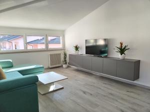 a living room with a couch and a flat screen tv at Sweet Home Longarone in Longarone