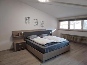 ein Schlafzimmer mit einem Bett in einem Zimmer mit Fenster in der Unterkunft Sweet Home Longarone in Longarone + 9 Fotos