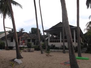 een huis aan het strand met palmbomen bij Palm Point Village in Mae Nam