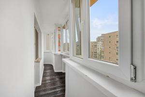 an empty corridor with white windows in a building at Modern 1BR Retreat Cofee & Peace in Bucharest