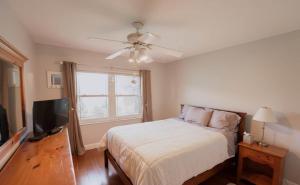 a bedroom with a bed and a flat screen tv at Poolside Miami Paradise with BBQ & Outdoor Lounge in Country Walk