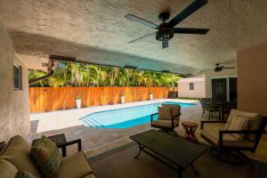 a living room with a pool and a ceiling fan at Poolside Miami Paradise with BBQ & Outdoor Lounge in Country Walk +31 photos