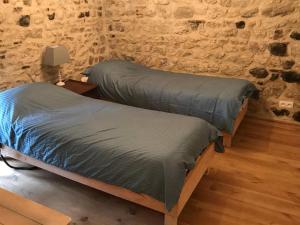 two beds in a room with a stone wall at Lapeyrouse Bonnet in Montmirail
