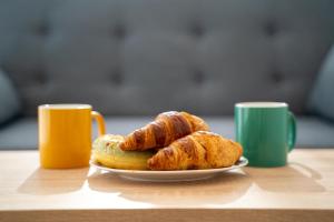een bord met croissants en gebak op een tafel met twee kopjes bij Apartamento familiar en Torreblanca con vistas al mar, aire acondicionado y cerca de la playa in Torreblanca +22 foto's