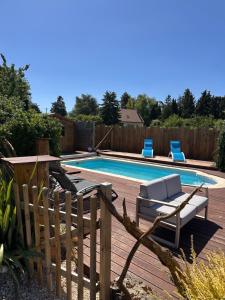 a swimming pool with two lounge chairs next to it at La Ferme Oasis in Belloy