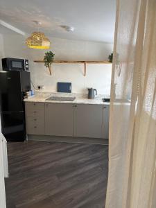 a kitchen with a black refrigerator and white cabinets at Quirky renovated apartment Glastonbury in Glastonbury +11 photos