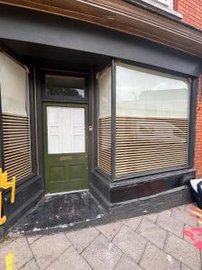a green door in a building with windows at Quirky renovated apartment Glastonbury in Glastonbury