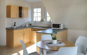 una cucina con tavolo, sedie e forno a microonde di H7 Og a Marienfelde