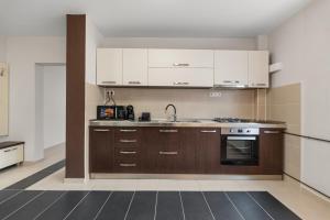 a kitchen with white cabinets and a sink at Modern 1BR Retreat Cofee & Peace in Bucharest +19 photos