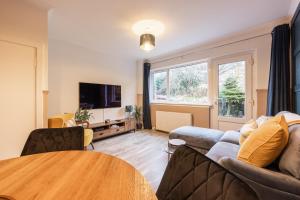 un salon avec un canapé et une table dans l'établissement Bright 1-Bed Home with Garden Near Braid Hills Golf Course, à Édimbourg