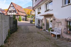 eine weiße Bank vor einem weißen Gebäude in der Unterkunft Lepold's Balkenzauber - Sasbachwalden zentral, mit Kamin und Weinbergblick, für 6 Personen, familienfreundlich in Sasbachwalden