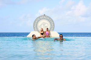 a group of people in the water in the ocean at Papagayo Beach Hotel in Willemstad