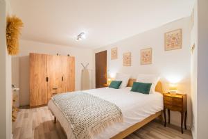 une chambre avec un lit blanc et une armoire en bois dans l'établissement Cozy Old Town Suite - Quiet and Central Cocoon, à Sélestat