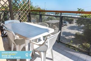 a table and chairs on a balcony with a fence at Appartamento a Senigallia in Lungomare Da Vinci - SE006 in Senigallia