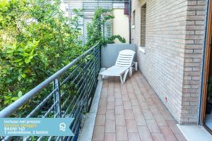 a white chair sitting on a balcony next to a brick wall at Appartamento a Senigallia in Lungomare Da Vinci - SE006 in Senigallia