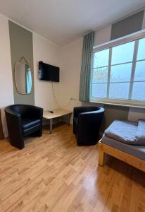 Un dormitorio con una cama y un escritorio y una ventana. en Zimmer 4, en Bullendorf 3 fotos más