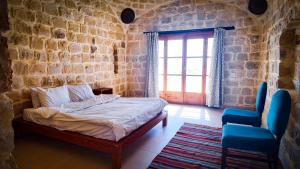 a bedroom with a bed and a window and a chair at Tache By The Lake in Fayoum