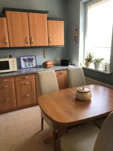 a kitchen with a wooden table and a microwave at FeWo M Becker 