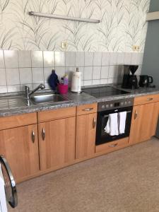 a kitchen with a sink and a stove at FeWo M Becker 