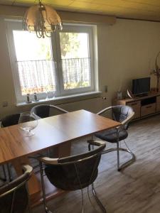 a dining room with a wooden table and chairs at FeWo M Becker in Athenstedt