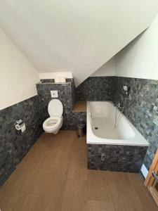 ein Badezimmer mit Toilette und Badewanne in der Unterkunft Ferienwohnung im Stenhuus in Wiek auf Rügen 