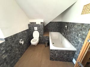 ein Badezimmer mit Toilette und Badewanne in der Unterkunft Ferienwohnung im Stenhuus in Wiek auf Rügen 