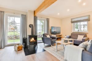 a living room with a couch and a fireplace at Ferienhaus Hygge - nordisches Flair in Toplage in Wiek auf Rügen