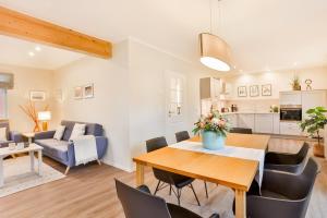 a dining room and living room with a table and chairs at Ferienhaus Hygge - nordisches Flair in Toplage in Wiek auf Rügen
