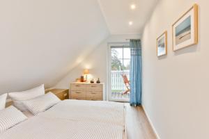 a bedroom with two beds and a window at Ferienhaus Hygge - nordisches Flair in Toplage in Wiek auf Rügen