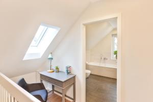 a white bathroom with a desk and a sink at Ferienhaus Hygge - nordisches Flair in Toplage in Wiek auf Rügen +28 photos
