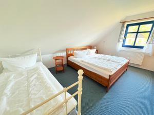 een slaapkamer met twee bedden en een raam bij Ferienhaus Arkona Putgarten in Putgarten