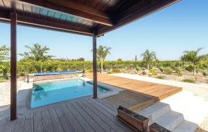 a swimming pool on a wooden deck with a patio at Beautiful Home In Guardamar Del Segura in El Camino de Catral +27 photos