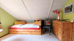 a bedroom with a wooden bed and a wooden dresser at Ferienhaus Julchen Samtens - mit Garten, Grillplatz, Sauna in Samtens