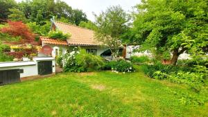a house with a yard with green grass at Ferienhaus Julchen Samtens - mit Garten, Grillplatz, Sauna in Samtens