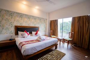 Un dormitorio con una cama grande y una ventana grande en Krishna Inn - Royal Hotels, en Kolhapur 174 fotos más