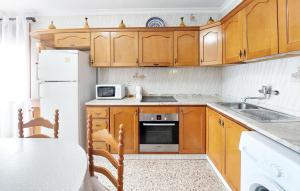 a kitchen with wooden cabinets and a white refrigerator at Casa Traiguera in Traiguera