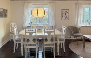 a dining room with a table and chairs and a window at Awesome Home In Skagen With Wifi in Hulsig
