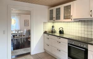 a kitchen with white cabinets and a tea kettle on the counter at Awesome Home In Skagen With Wifi in Hulsig +3 photos