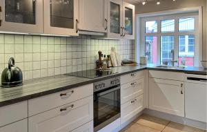 a kitchen with white cabinets and a stove top oven at Awesome Home In Skagen With Wifi in Hulsig