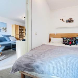 una camera da letto con un letto e un divano blu di Ferienwohnung Kajüte 7211 Marina Wendtorf a Wendtorf