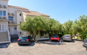 three cars parked in a parking lot in front of a building at Cozy Apartment In Sreser With Wifi in Sreser
