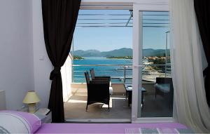 a bedroom with a balcony with a view of the ocean at Cozy Apartment In Sreser With Wifi in Sreser