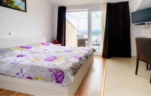 a bedroom with a bed and a view of the ocean at Cozy Apartment In Sreser With Wifi in Sreser