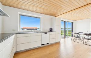 Vilsund VestにあるAwesome Home In Thisted With House Sea Viewの白いキャビネットと大きな窓のあるキッチン