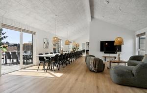 a living room with a dining room table and chairs at Amazing Home In Glesborg With Sauna in Fjellerup